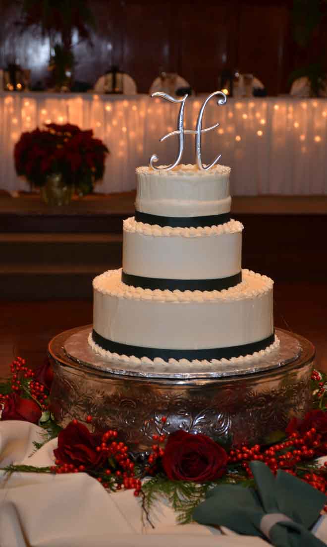 Cake table place setting with holly buds Christmass decor at The Corinthian Event Center.