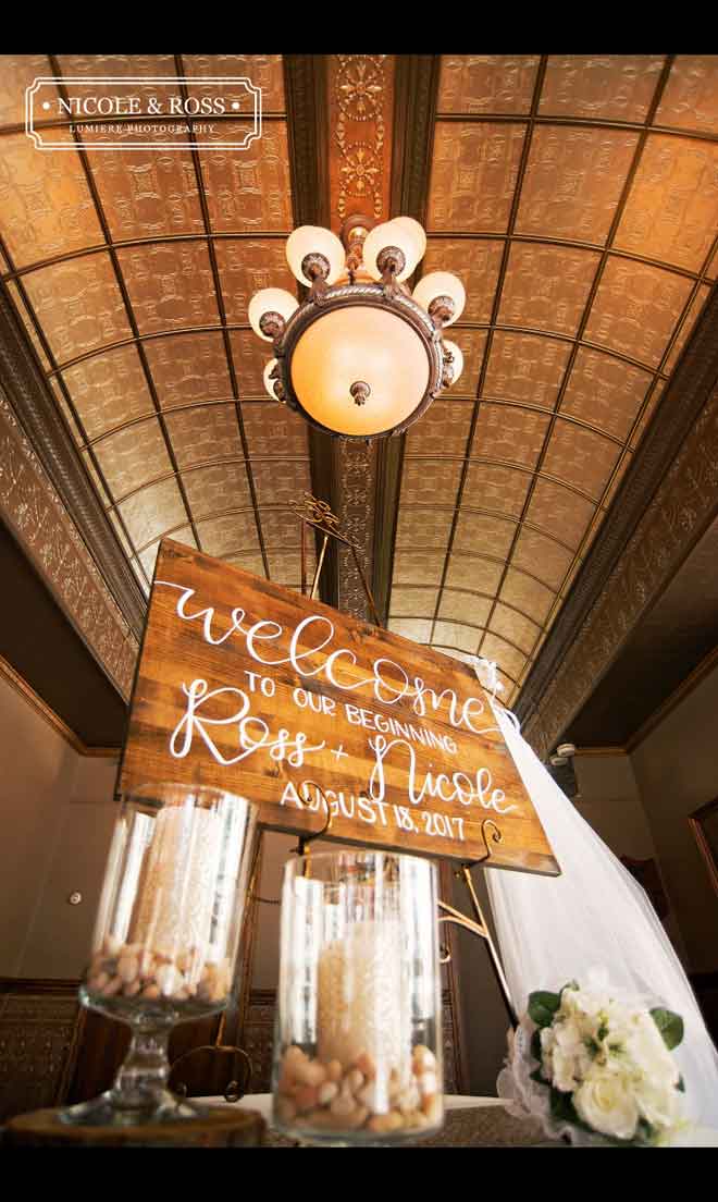 Welcome sign and lobby centerpiece decor at The Corinthian Event Center.