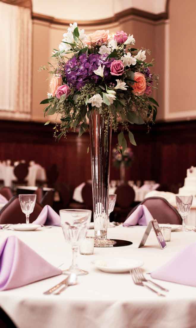 Flower centerpiece and place setings at The Corinthian Event Center.