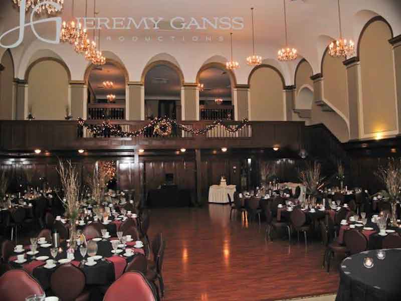 Grand Ballroom setup in black theme with chair covers, branches centerpieces, and white plate place settings at The Corinthian Event Center.