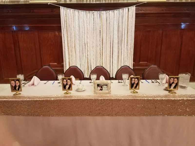 Head table setup on Grand Ballroom stage with backdrop in pink theme at The Corinthian Event Center.