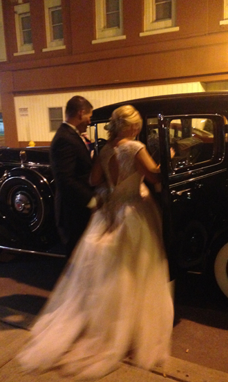 Bride and groom enter vintage car outside The Corinthian Event Center.